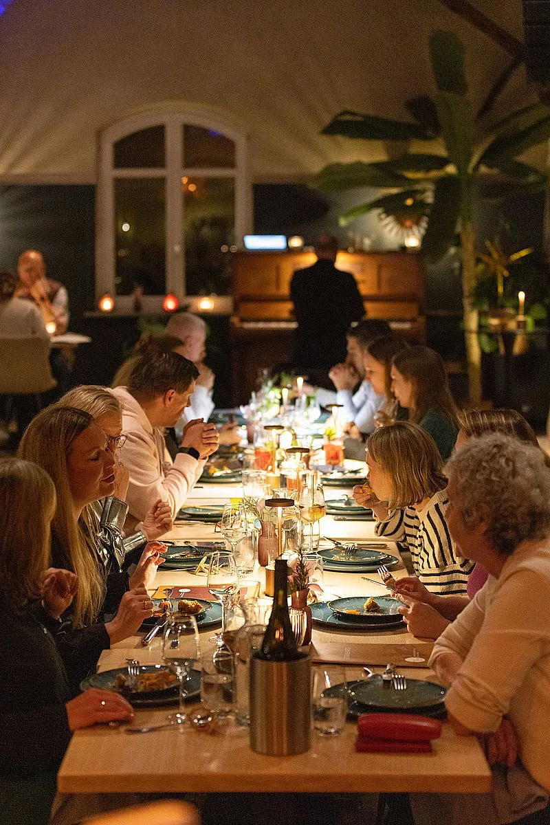 Gäste genießen gemeinsam einen Abend an der langen Tafel